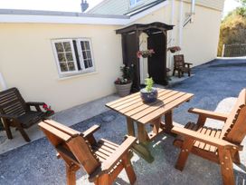 An outdoor seating area with wooden chairs and a table at Dolcoed in Manordeilo near Llangadog