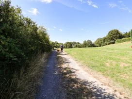 A person walking a dog on a path in a field at Dolcoed Manordeilo near Llangadog