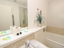 A bathroom with a bathtub sink mirror and potted plant at Cape 12 Near Yarmouth
