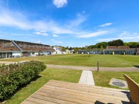 A grassy open area with pathways and small houses surrounding it at Cape 14 in Yarmouth