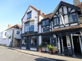 Exterior view of the bugle coaching inn building on a street with potted plants outside