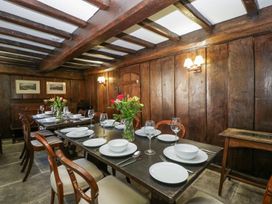 A dining room with wooden beams and paneling set with white dishes and glasses at White Haywood Farmhouse & Barn in Craswall