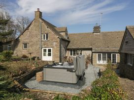 An outdoor hot tub with bubbling water in a garden area next to a stone house at White Haywood Farmhouse & Barn in Craswall