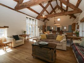 A living room with wooden beams sofas tables and dining area at White Haywood Farmhouse & Barn in Craswall