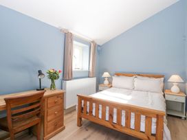 A bedroom with a wooden bed and desk with a chair and lamps at White Haywood Farmhouse & Barn in Craswall