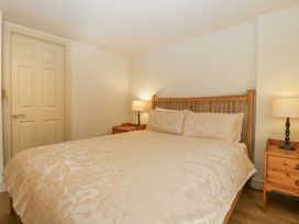 A bedroom with a double bed wooden headboard bedside tables with lamps and a closed door at White Haywood Farmhouse & Barn in Craswall