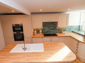 A kitchen with a sink, countertop, oven and stove top at 5 Lombard Street, Porthmadog