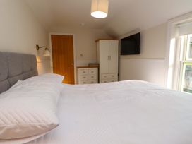 A bedroom with a bed, wardrobe, and TV at 5 Lombard Street Porthmadog