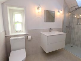 A bathroom with a shower, sink and window at 5 Lombard Street in Porthmadog