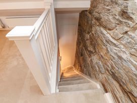 A staircase with a stone wall and railing at 5 Lombard Street in Porthmadog