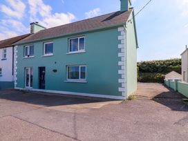 A house with green exterior and driveway at O'Conells in Portmagee