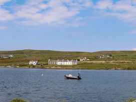 A view of houses and a boat on water at O'Conells Portmagee