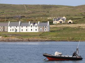 A house and a boat on water at O'Conells in Portmagee