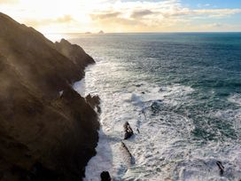 A coastal view showing cliffs, ocean waves, and distant islands at O'Conells in Portmagee