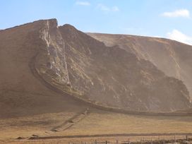 A cliff with a slope and grass at O'Conells in Portmagee