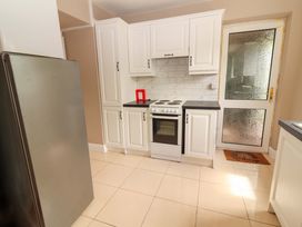 A kitchen with a fridge, oven, and cabinets at O'Connell's Lodge, Portmagee, County Kerry