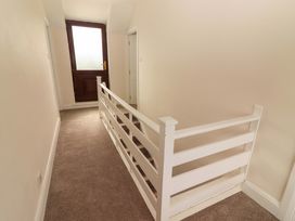 A hallway with a white railing and a door at O'Connell's Lodge, Portmagee, County Kerry