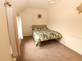 A bedroom with a bed and curtains at O'Connell's Lodge in Portmagee, County Kerry