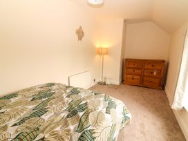 A bedroom with a bed, lamp, and wardrobe at O'Connell's Lodge in Portmagee, County Kerry