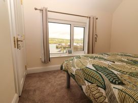 A bedroom with a bed and a window view at O'Connell's Lodge in Portmagee, County Kerry