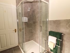 A shower with glass doors and towels in a bathroom at O'Connell's Lodge, Portmagee, County Kerry