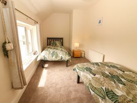 A bedroom with two beds and a lamp on a nightstand at O'Connell's Lodge in Portmagee, County Kerry