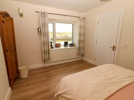 A bedroom with a window and wardrobe at O'Connell's Lodge, Portmagee, County Kerry