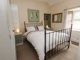 A bedroom with a bed and bedside table at Sygun Cottage in Nant Gwynant