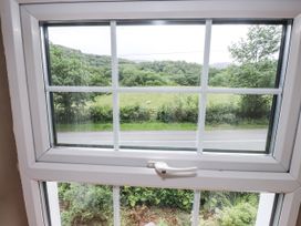 A window showing a view of grass and trees at Sygun Cottage in Nant Gwynant