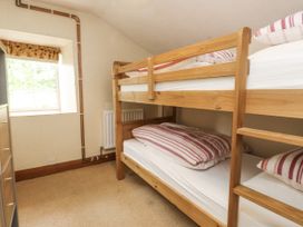 A bedroom with bunk beds and a window at Sygun Cottage in Nant Gwynant