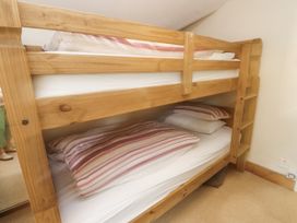 A bunk bed with pillows and mattresses at Sygun Cottage in Nant Gwynant