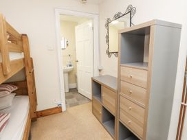 A bedroom with a bunk bed and storage drawers at Sygun Cottage in Nant Gwynant