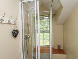 A bathroom with a shower enclosure and window at Sygun Cottage Nant Gwynant