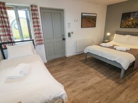 A bedroom with one single bed and one double bed with towels on them at Beech in Cowbridge
