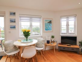 A dining room with a round table and flowers at 61B Fore Street in Kingsbridge