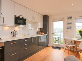 A kitchen with modern appliances and a small dining table at 61B Fore Street Kingsbridge