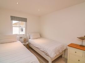 A bedroom with two beds and a window at 61B Fore Street Kingsbridge