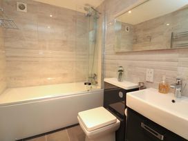 A bathroom with a bathtub, shower, toilet, and sink at 61B Fore Street in Kingsbridge