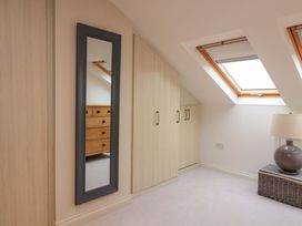 A bedroom with a mirror, wardrobe, and dresser at 61B Fore Street in Kingsbridge
