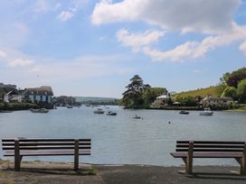 A view of a river with boats and benches at 61B Fore Street in Kingsbridge