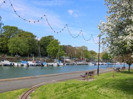 A view of a marina with boats and benches at 61B Fore Street in Kingsbridge
