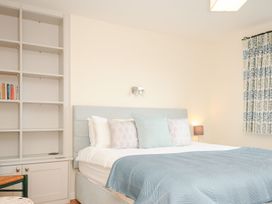 A bedroom with a bed and bookshelf at Chimings in Rock