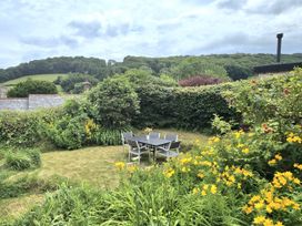 A garden with a table and chairs surrounded by flowers at Picket Mead Southleigh near Colyton