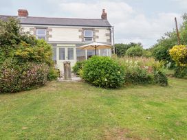 An outdoor area with a house, garden, and an umbrella at Nanvivian in Feock near Truro