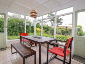 A conservatory with a table and chairs at Nanvivian in Feock near Truro