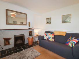 A living room with a grey sofa and fireplace at Nanvivian in Feock near Truro