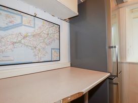 A kitchen with a map on the wall and a fridge at Nanvivian Feock near Truro