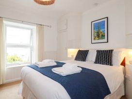 A bedroom with a bed and window at Nanvivian in Feock near Truro