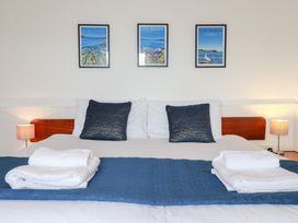 A bed with pillows and artwork on the wall at Nanvivian Feock near Truro