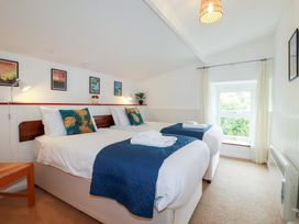 A bedroom with two beds and curtains at Nanvivian in Feock near Truro